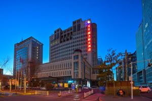 eine Gruppe von hohen Gebäuden in einer Stadt in der Nacht in der Unterkunft Uiles Hotel in Hohhot
