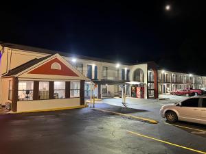 a parking lot in front of a building at night at Scottish Inn Augusta downtown in Augusta