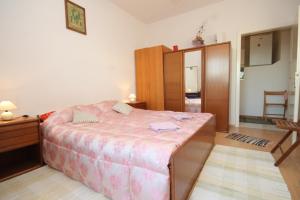 特斯特諾的住宿－Apartments with a parking space Trsteno, Dubrovnik - 8594，一间卧室配有一张大床和一个木制橱柜