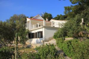 a white house sitting on top of a hill at Apartments by the sea Rogac, Solta - 8688 in Grohote