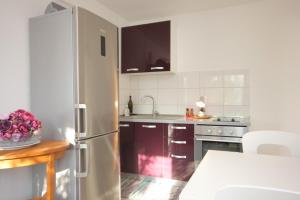 a kitchen with a stainless steel refrigerator and a table at Apartments by the sea Rogac, Solta - 8688 in Grohote