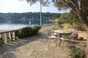 a patio with a table and chairs next to a lake at Apartments by the sea Rogac, Solta - 8688 in Grohote