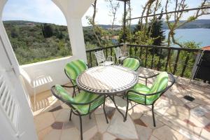 a patio with a table and chairs on a balcony at Apartments by the sea Necujam, Solta - 8691 in Nečujam