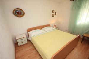 a small bedroom with a bed and a chair at Apartments by the sea Necujam, Solta - 8691 in Nečujam