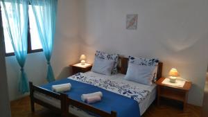 a bedroom with a bed with blue sheets and pillows at Apartments with a parking space Rukavac, Vis - 8863 in Rukavac