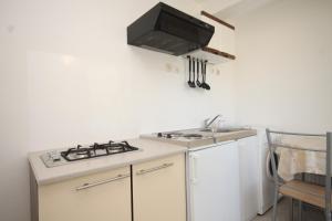 a white kitchen with a stove and a sink at Apartments with a parking space Rukavac, Vis - 8863 in Rukavac