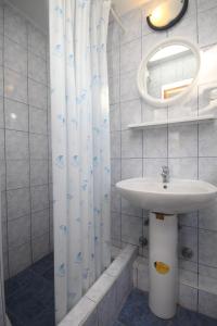 a bathroom with a sink and a shower curtain at Apartments with a parking space Rukavac, Vis - 8863 in Rukavac