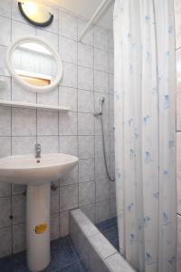 a bathroom with a sink and a shower curtain at Studio Rukavac 8863a in Rukavac