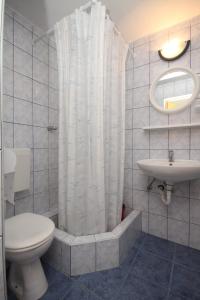 a bathroom with a toilet and a shower curtain at Apartment Rukavac 8863b in Rukavac