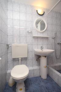 a white bathroom with a toilet and a sink at Apartment Rukavac 8863c in Rukavac