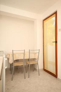 a dining room with a table and chairs and a door at Apartment Rukavac 8863c in Rukavac