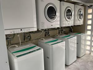 quatro máquinas de lavar roupa estão alinhadas numa lavandaria em Holiday Homes TSUBOYA 301 em Naha