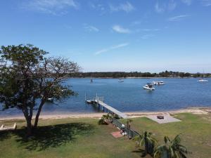 a dock on a lake with boats in the water at Lorsens on the River - Shoalhaven Heads in Shoalhaven Heads +37 photos