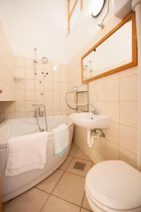 een badkamer met een bad, een toilet en een wastafel bij Studio Komiza 8844a in Komiža