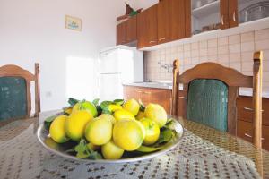 a bowl of lemons on a table in a kitchen at Studio Komiza 8844a in Komiža