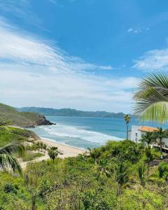 a view of a beach with a house and the ocean at Hotel Punta Serena & Resorts - Solo Parejas in Tenacatita