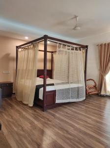 a bedroom with a canopy bed and a wooden floor at Hotel Bright Heritage in Cochin