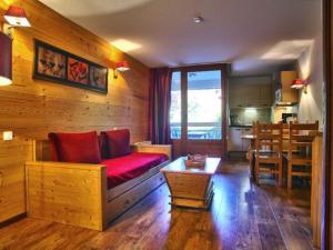 sala de estar con sofá rojo y mesa en Studio Brides-les-Bains, 1 pièce, 4 personnes - FR-1-512-247, en Brides-les-Bains