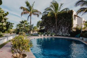 a swimming pool with palm trees and a building at Punta Esmeralda I in Altata