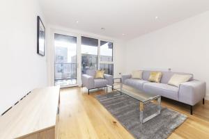 a living room with a couch and a coffee table at Stylish family sized 2 bedroom apartment in London