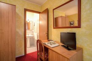 a room with a desk with a television and a mirror at Monti Guest House - Affittacamere in Rome