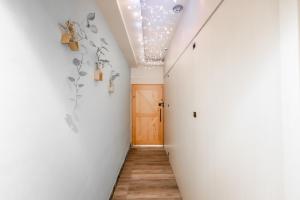 a hallway with a white wall and a door at 紫品花筑Purple Flower House in Anping