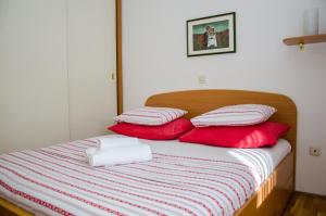 a bed with red and white pillows on it at Apartments with a parking space Split - 11072 in Split