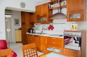 a kitchen with wooden cabinets and a stove top oven at Apartments with a parking space Split - 11072 in Split