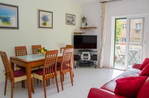 ein Wohnzimmer mit einem Tisch und Stühlen sowie einem TV in der Unterkunft Apartments with a parking space Split - 11072 in Split