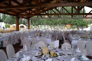 un salón de banquetes con mesas y sillas blancas en Sercotel Rey Sancho en Palencia