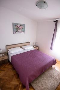 a bedroom with a bed with a purple blanket at Apartments by the sea Necujam, Solta - 11090 in Grohote