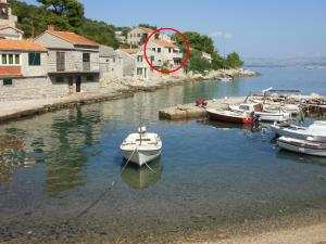 un pequeño barco en el agua junto a otros barcos en Apartments by the sea Cove Donja Kruscica - Donja Krusica, Solta - 11146 en Grohote