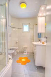 ein Bad mit einer Dusche, einem WC und einem gelben Teppich auf dem Boden in der Unterkunft Apartments by the sea Rogac, Solta - 11220 in Rogač