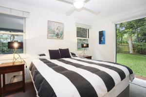a bedroom with a black and white bed and a window at Bella Luca Pet Friendly Home in Hawks Nest