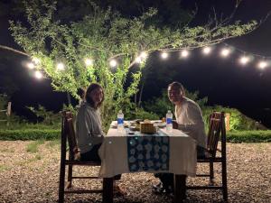 a man and woman sitting at a table at night at Sapa Rosie House in Sa Pa