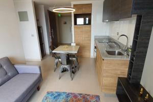 uma cozinha com um lavatório, uma mesa e um sofá em Departamento en el centro de concepción, 2 dorm. em Concepción