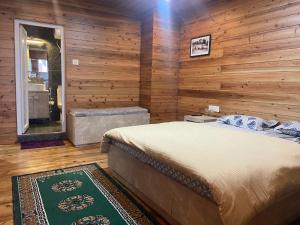a bedroom with wooden walls and a bed and a tub at Norbu Thungkar Homestay in Darjeeling
