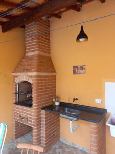 La cuisine est équipée d'un four en briques et d'un évier. dans l'établissement Casa de praia verde mar, à Itanhaém