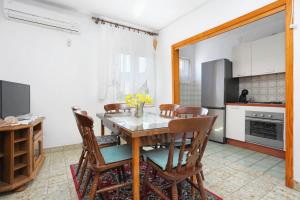 a kitchen and dining room with a table and chairs at Apartments by the sea Vinisce, Trogir - 11029 in Vinišće