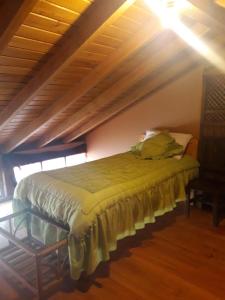 Cama en habitación con techo de madera en Chuza Longa Home, en Guamote