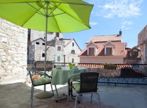 a table and chairs with a green umbrella on a patio at Apartments by the sea Split - 11161 in Split