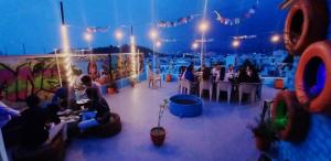 un groupe de personnes assises à des tables dans une pièce dans l'établissement Hill Paradise Home Stay, à Udaipur