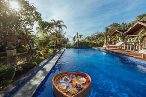 - une piscine du complexe avec un panier de nourriture dans l'établissement Bakung Cozy Cottage, à Nusa Penida