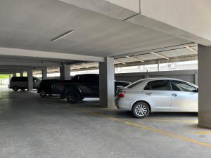 un garage avec deux voitures garées à l'intérieur dans l'établissement Naraigrand Hotel (โรงแรมนารายณ์แกรนด์), à Chai Badan