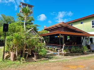 a restaurant with palm trees in front of a building at Cha-Cha Hotel in Ko Lanta