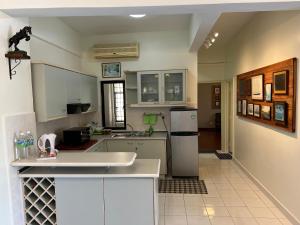 una cucina con armadietti bianchi e frigorifero bianco di Sevenseas Marina Crescent a Port Dickson