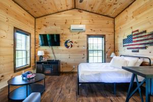 1 dormitorio con 1 cama en una habitación con paredes de madera en Patriots Tiny Home w Hot Tub Fire Pit Grill, en Sevierville
