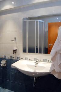 La salle de bains est pourvue d'un lavabo et d'un miroir. dans l'établissement Hotel Luxor, à Bourgas