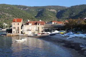 a group of boats sitting on the shore of a body of water at Apartments with a parking space Komiza, Vis - 12325 in Komiža