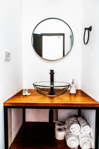 a bathroom with a glass sink and a mirror at WasiPai Boutique Hotel in Lima